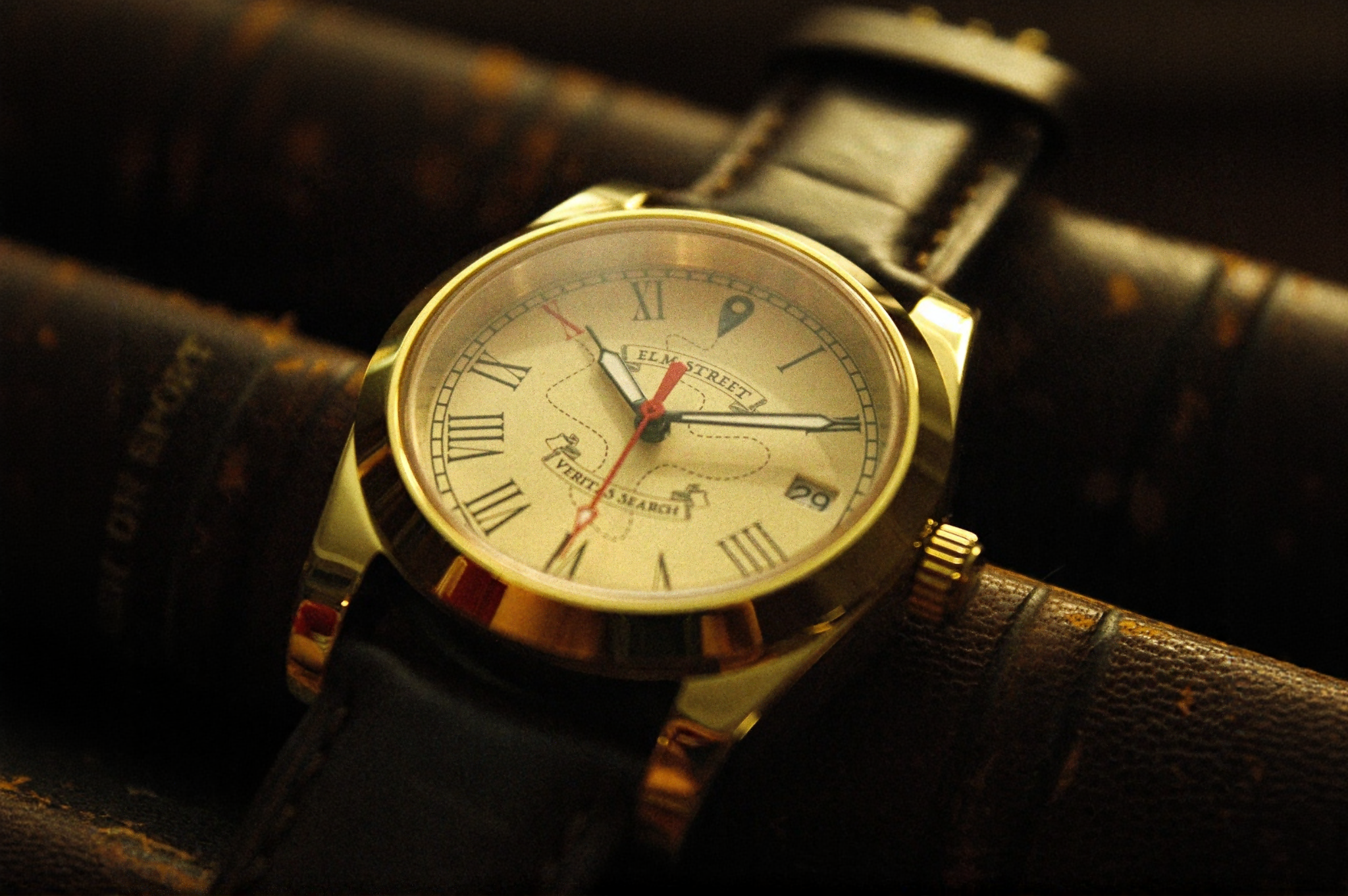 Gold wristwatch with a brown leather strap on a dark background